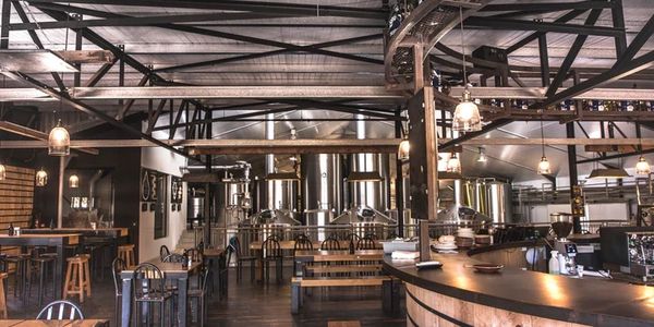 Spacious brewery taproom with wooden and metal furnishings.
