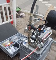 Portable pipe inspection or testing equipment setup on a street.