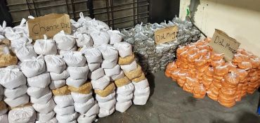 Bags of grains and pulses labeled in a storage area.