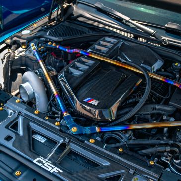 BMW engine bay with carbon-fiber cover and upgraded turbo hardware.