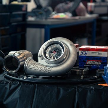 Precision turbocharger and performance hardware on a workshop bench.