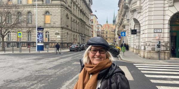 Smiling woman in winter clothes on a city street.
