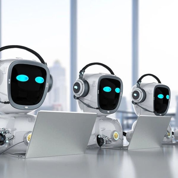 Three robots with headphones working on laptops in a bright office.
