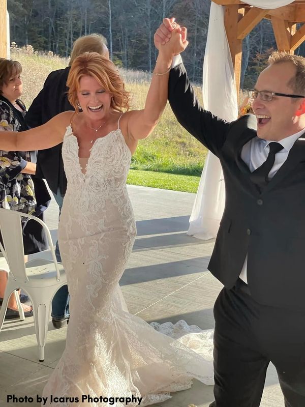 Bride and Groom with raised hands celebrating their pronouncement. 