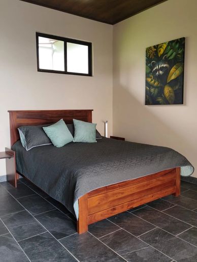 Dormitorio con cama de madera y decoración sencilla.