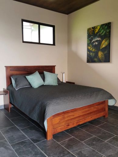 Dormitorio con cama de madera y decoración sencilla.