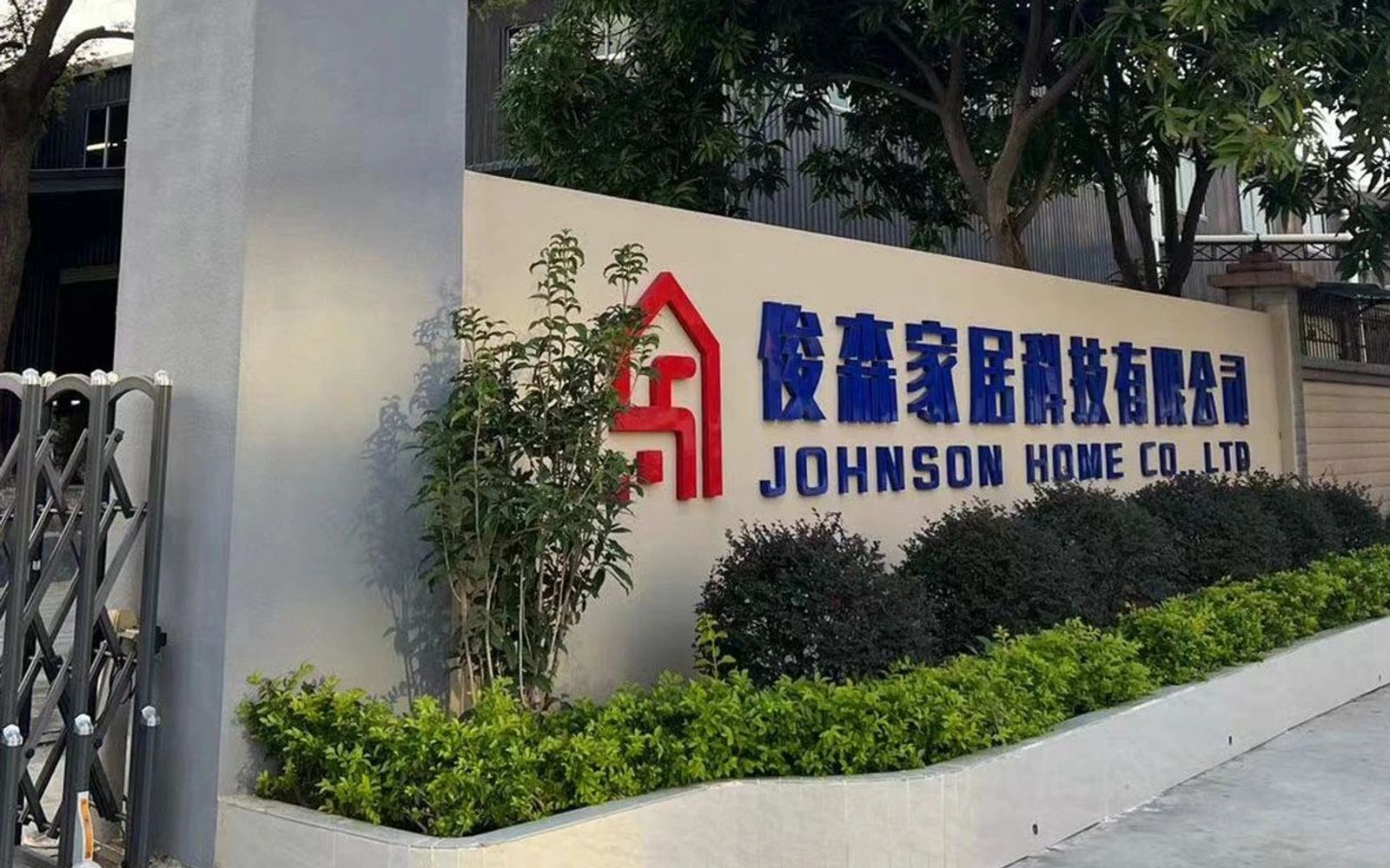 Signboard of Johnson Home Co. Ltd with greenery around it.