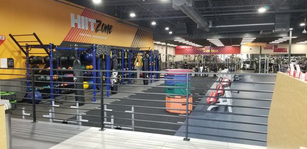 Empty modern gym with weight equipment and HIIT zone.