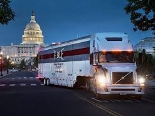 A large HBL truck in front of the U.S. Capitol at dusk.