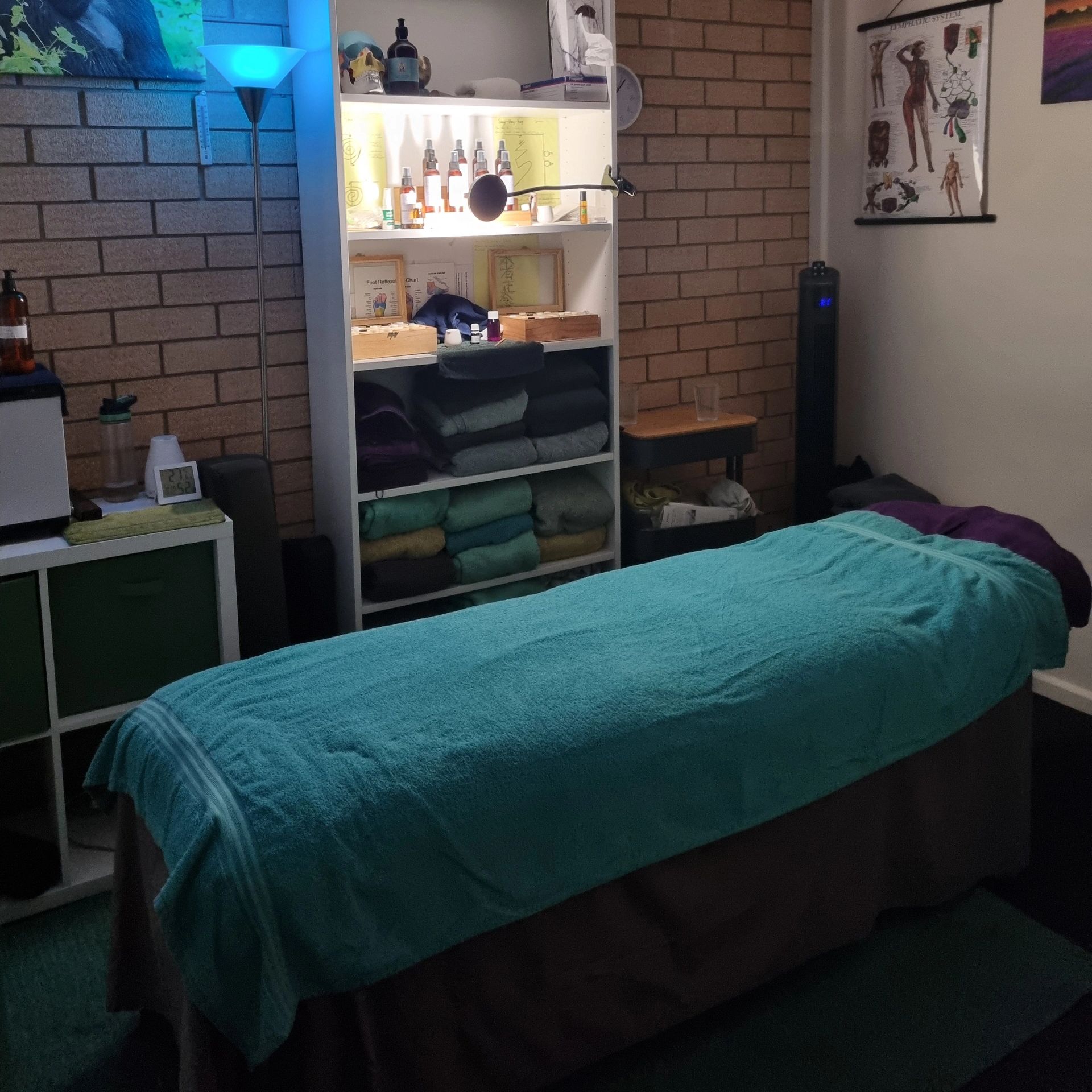 Cozy therapy room with a massage table and neatly arranged supplies.