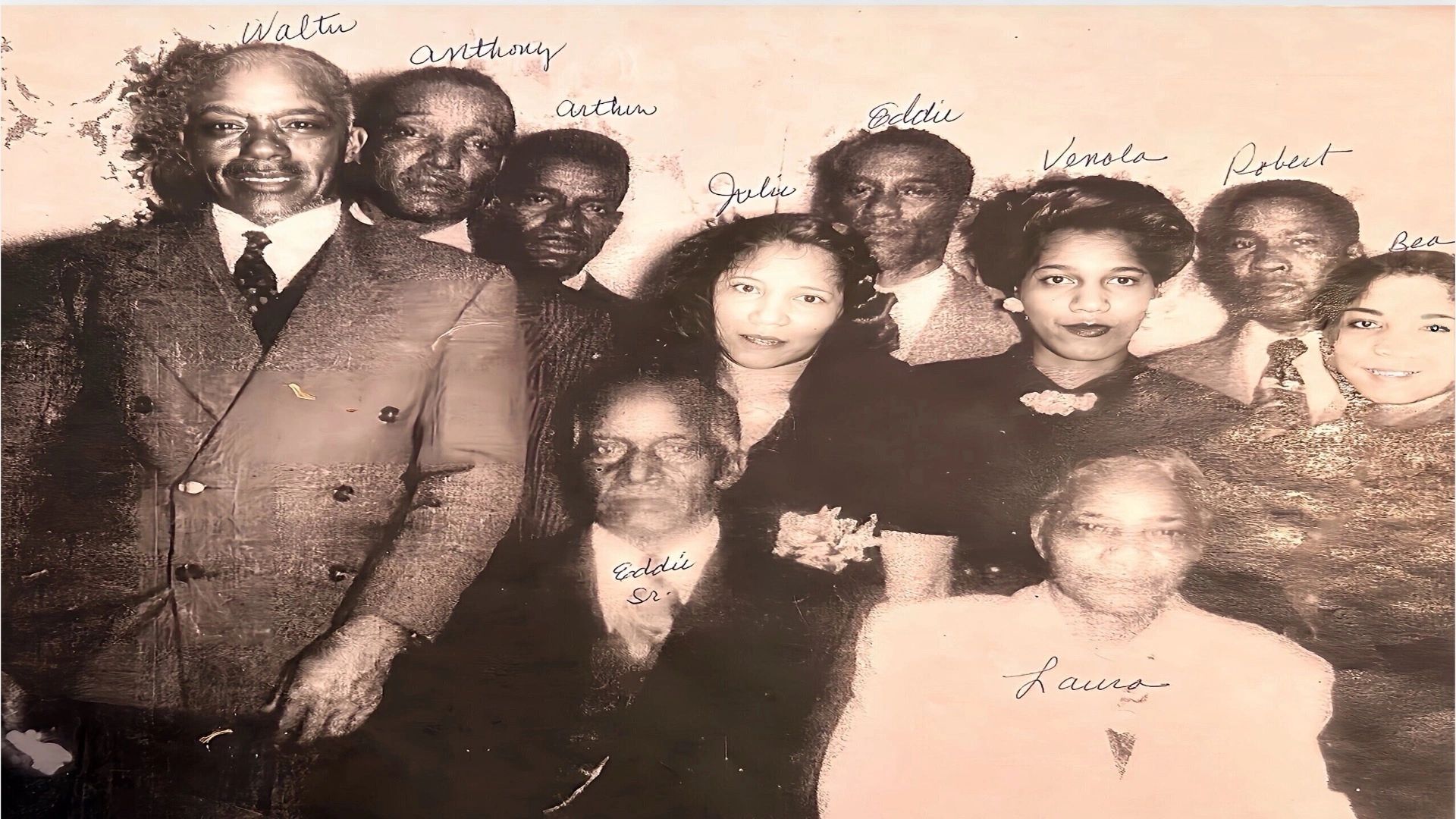 Black and white group portrait of nine people with handwritten names above their heads.