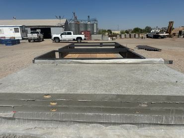 Metal sheets stacked outdoors with industrial background.