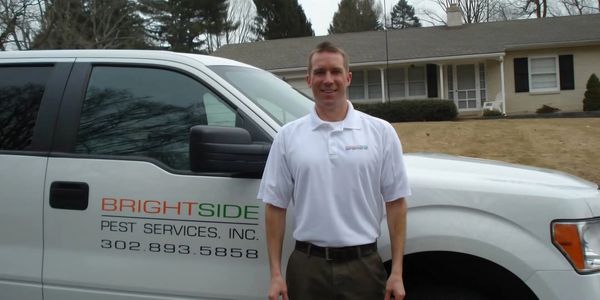 Man standing in front of a Brightside Pest Services truck.