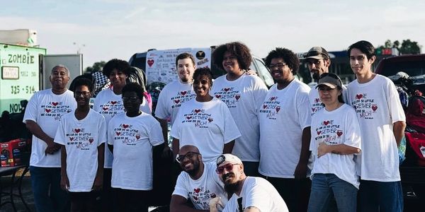 Group of people wearing matching T-shirts with a positive message, posing outdoors.