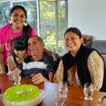 Family gathered around a table with green gelatin dessert, smiling joyfully.