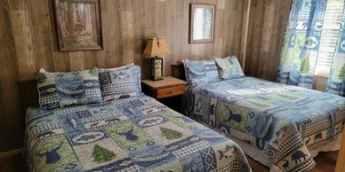 Cozy rustic bedroom with two beds and patterned bedding.