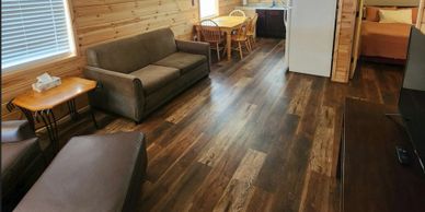 Cozy living room with wooden floors and furniture in a cabin-style interior.