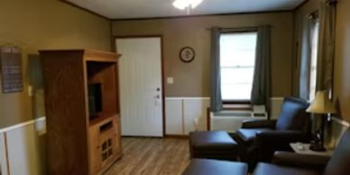 Cozy living room with wooden furniture and comfortable seating.