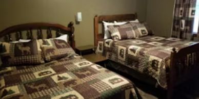 Cozy bedroom with two wooden beds and nature-themed bedding.