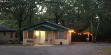 Cozy small house with porch lights on at dusk.