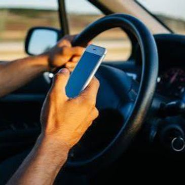 Person texting on phone while driving.