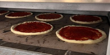 Fresh pizzas and hot prepared foods cooking in-store at Dayly’s Farm Market, ready for quick meals a