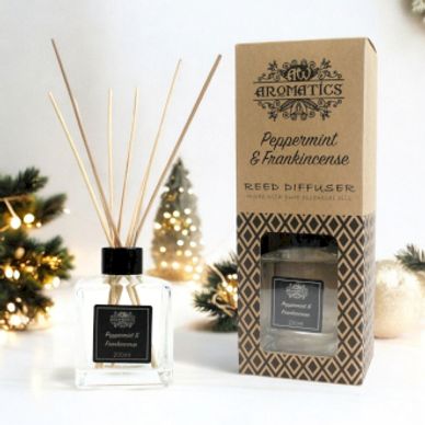 Peppermint & Frankincense reed diffuser display surrounded with Christmas decorations