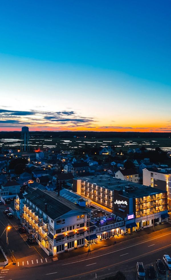 A lit hotel at dusk with a colorful sunset.