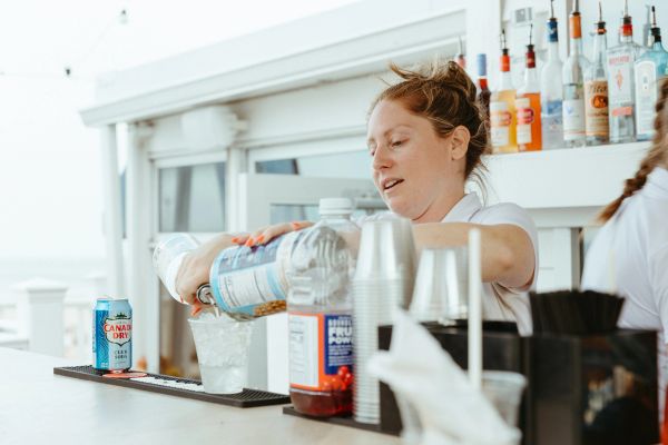 Bartender pouring a drink behind a bar counter.