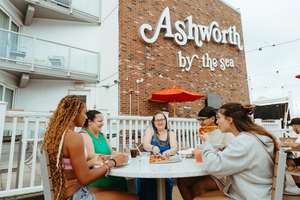 Friends eating pizza outdoors at Ashworth by the sea.