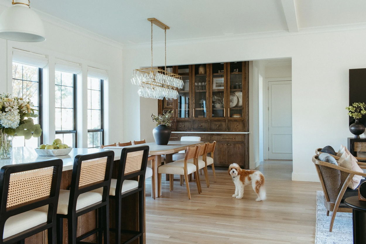 Bright Southlake kitchen and dining room with white cabinetry, natural wood island, and black-framed windows.