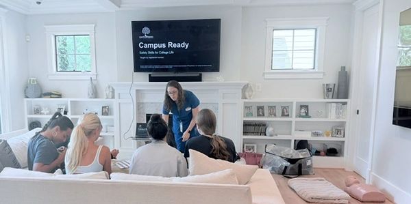 A woman teaching a group of people in a living room setting.