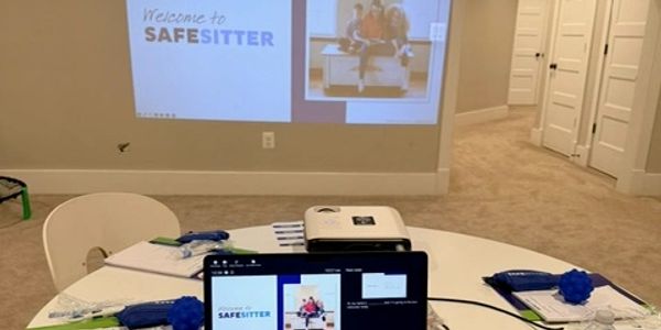 Setup for a SafeSitter training session with projector and laptop.