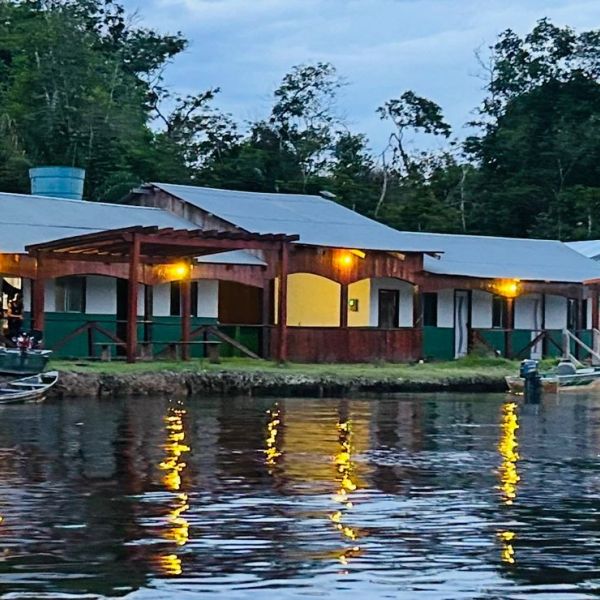 Casa à beira do lago iluminada ao entardecer.