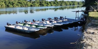 Barcos alinhados em um rio calmo.