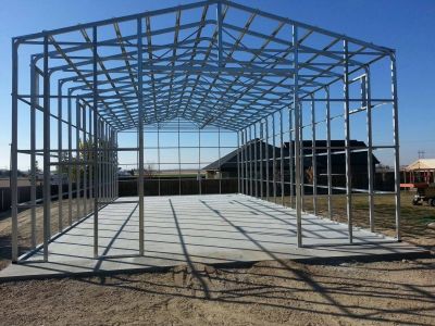 Steel frame structure under construction in open area.