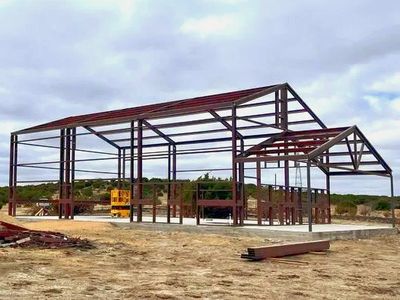 Steel frame structure under construction in open land.