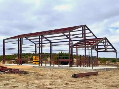 Steel frame structure under construction in open land.