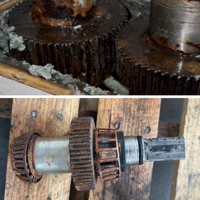 Close-up view of rusty metal gears and a mechanical shaft.