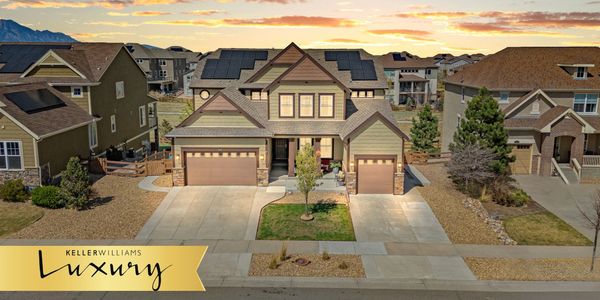 Spacious suburban house with solar panels at sunset.