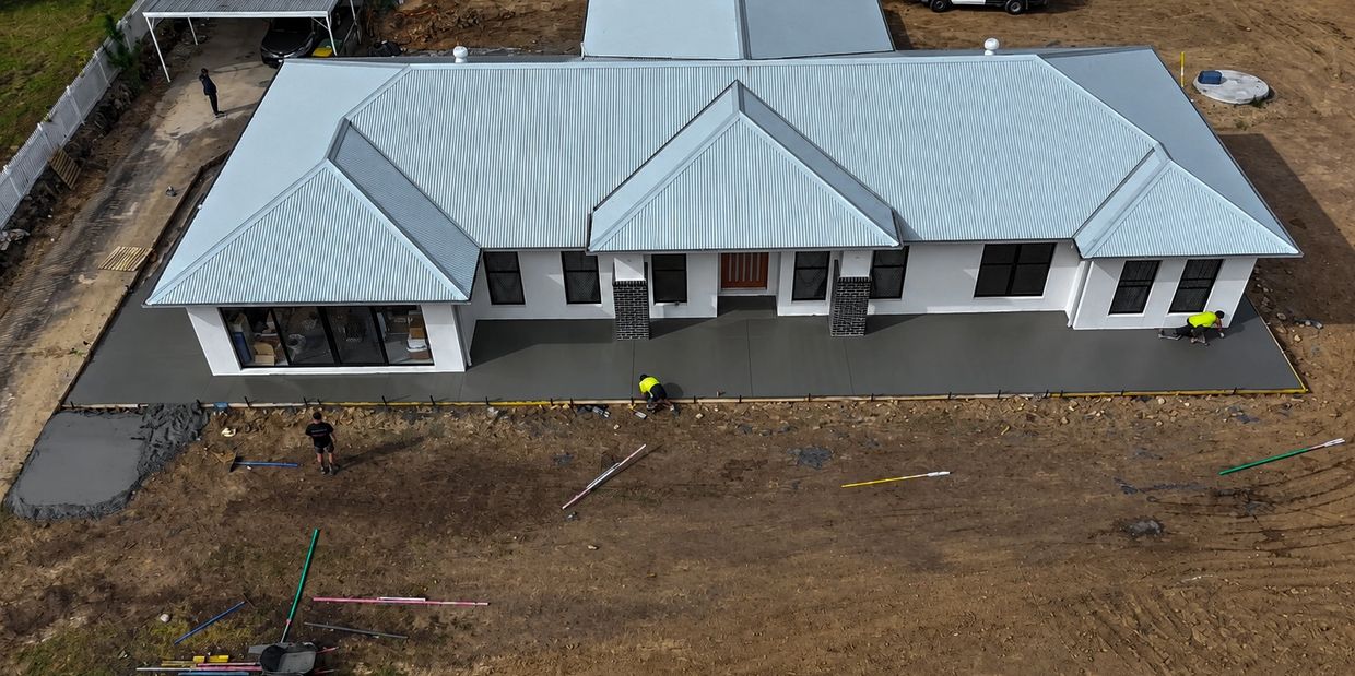 New house with fresh concrete patio being finished.