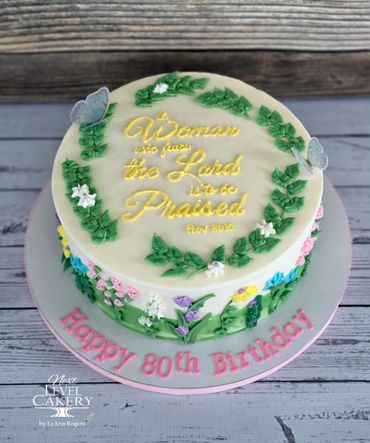 Elegant floral birthday cake with a biblical verse and butterflies.
