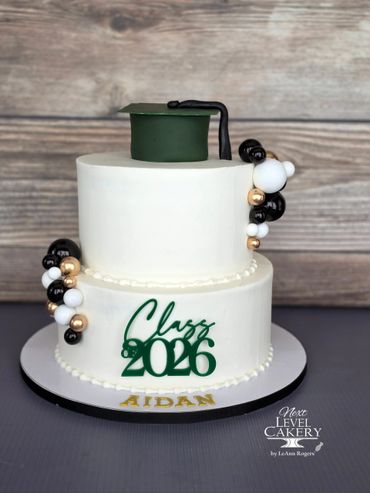 Elegant two-tier graduation cake with green cap and beads, celebrating Class of 2026 for Aidan.