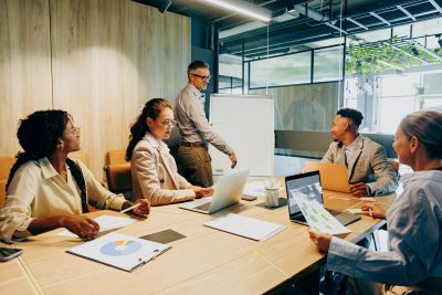 Colleagues in a meeting discussing work around a conference table.