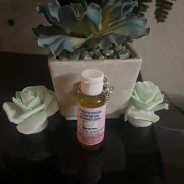 Essential oil bottle with decorative succulent and rose-shaped holders.