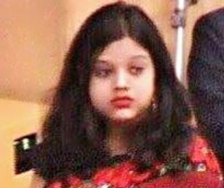 Young girl with long dark hair wearing a red outfit.