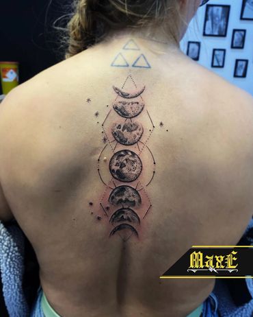 Geometric moon phase tattoo on upper back with fine dot work and stars.