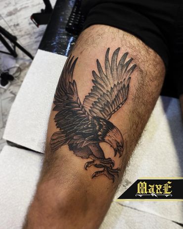 Detailed eagle tattoo on a person's thigh with wings spread wide.