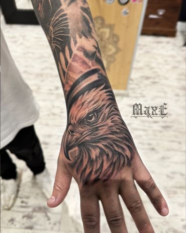 Detailed eagle tattoo covering hand and wrist with intricate shading.