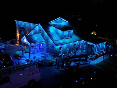 A house illuminated with blue lights at night.